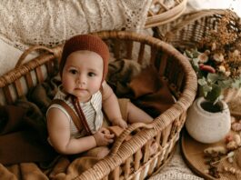 A Baby Sitting in a Basket with Autumnal Decorations // Healthier Baby Today