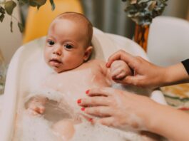 baby wit big eyes, baby bathing in baby bath. bubbles, mom washing // Healthier Baby Today