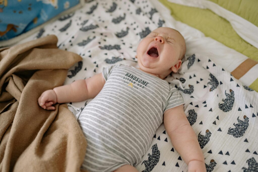 baby on mat, tired, yawing, animal print blanket // Healthier Baby Today