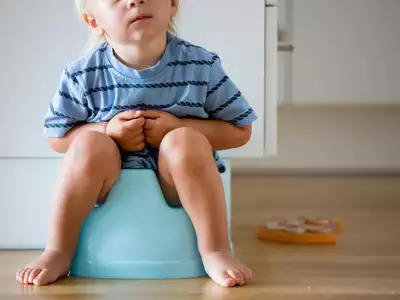 potty training boys, baby boy sitting on baby toilet, wearing blue // Healthier Pets Today