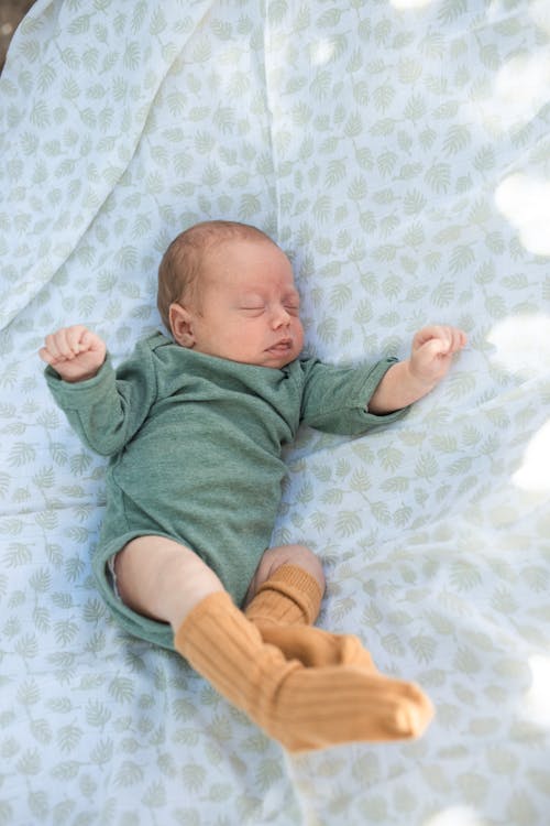A Newborn Baby in Onesie Sleeping // Healthier Baby Today