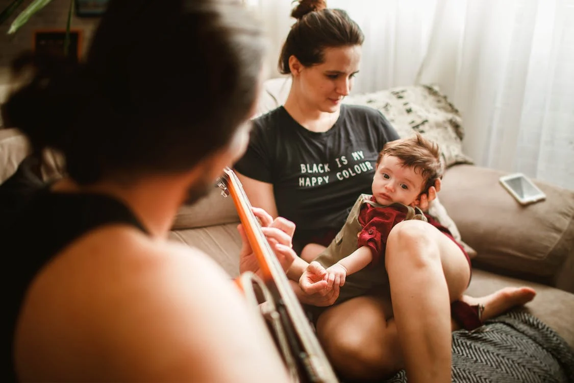 Music Baby Development, Anonymous father playing guitar on couch for baby and wife // Healthier Baby Today