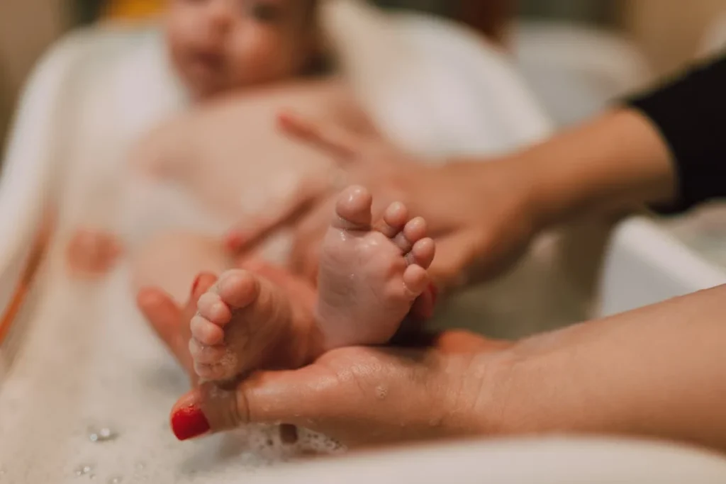 Baby Oil Uses, Small Feet of a Baby being washed // Healthier Baby Today