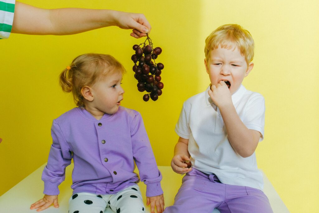 Person Holding Grapes Between Boy and Girl // Healthier Baby Today
