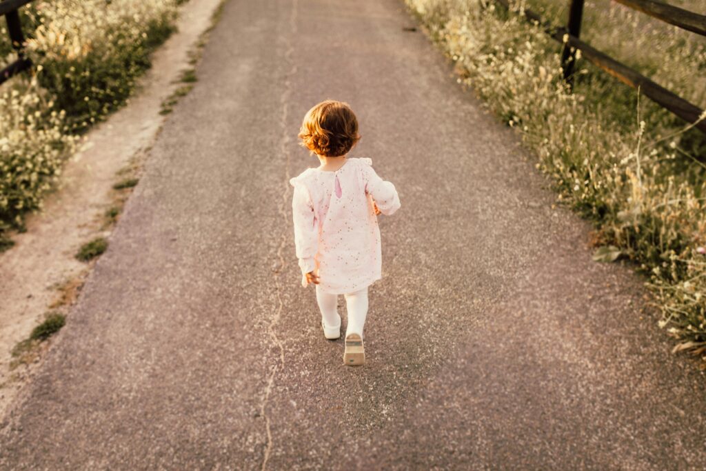 Photo Of Toddler Walking On Road, Brown Shoes, Wearing White and Pink // Healthier Baby Today