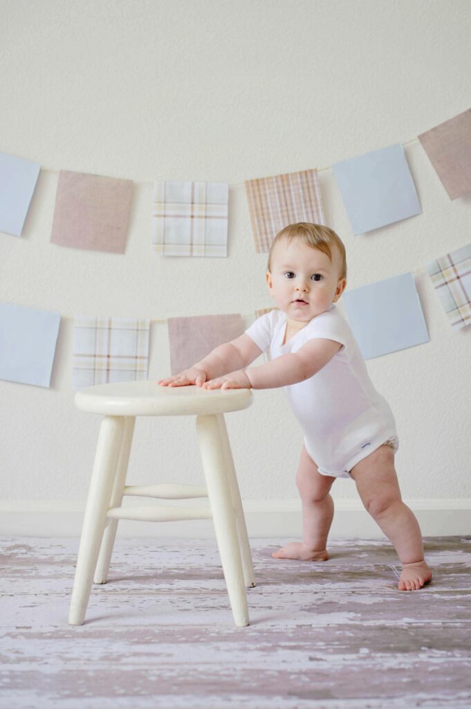 Baby Holding White Wooden Stool // Healthier Baby Today