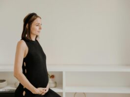 Maternity Shoot of a Woman in Black Tank Dress Holding her Tummy // Healthier Baby Today