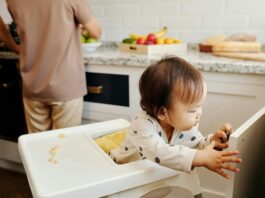 A Toddler on a High Chair Opening a Cabinet Door // Healthier Baby Today