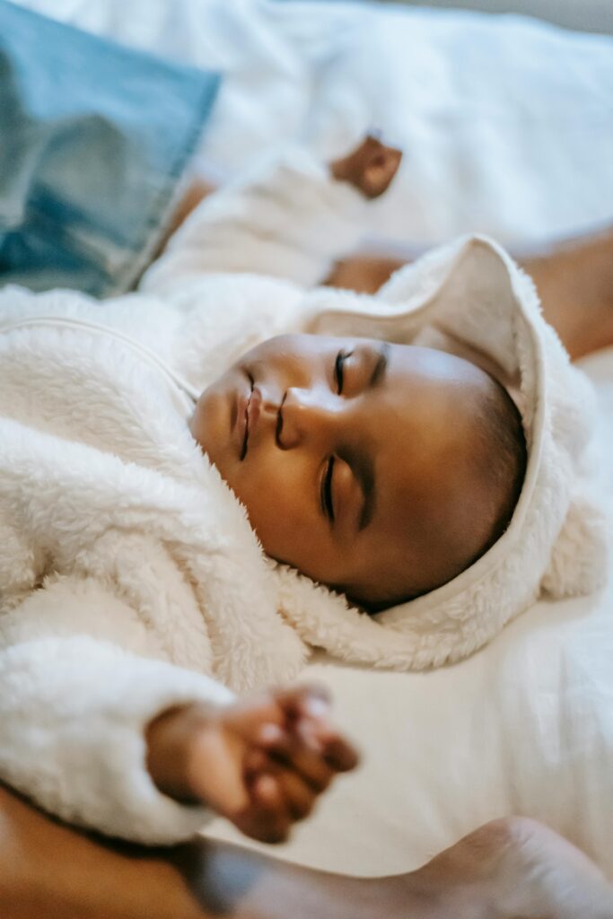 Adorable black infant baby sleeping on bed // Healthier Baby Today
