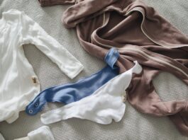 secondhand clothing, Clothes for newborn placed on bed // Healthier Baby Today
