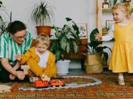 Indoor, Mother and two siblings playing with toy train at home // Healthier Baby Today