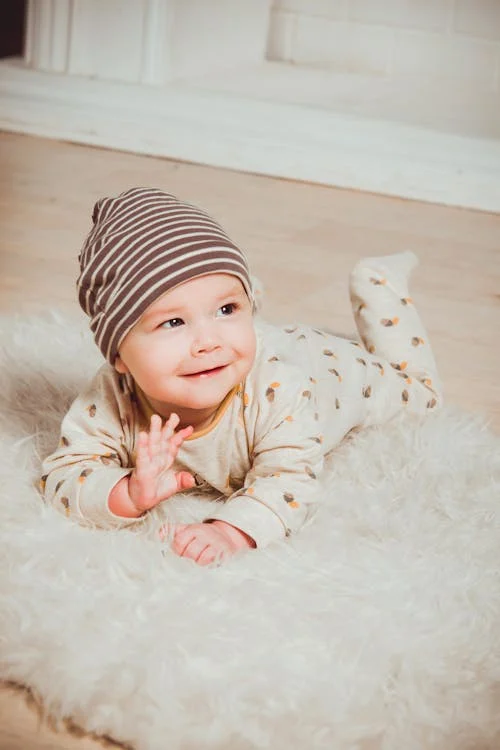Smiling Baby Lying on White Mat // Healthier Baby Today
