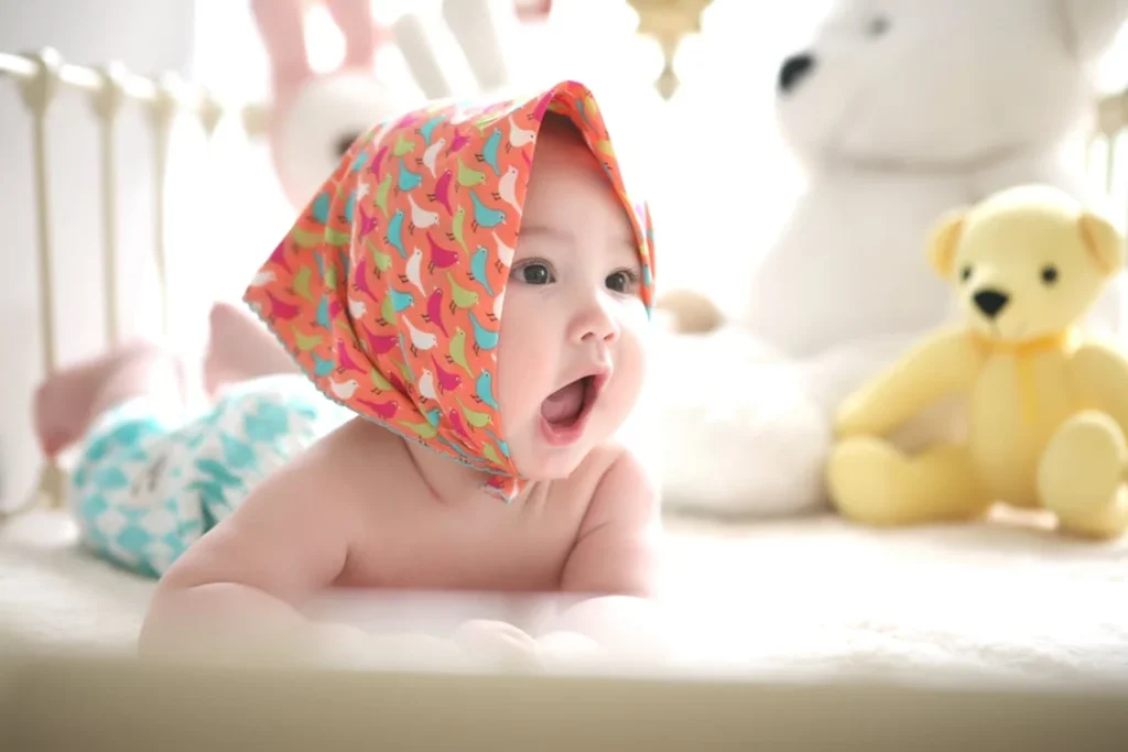 when can babies hold their head up, Toddler Wearing Head Scarf in Bed // Healthier Baby Today