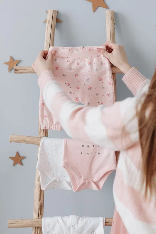 Woman Hanging Baby Clothes on a Ladder // Healthier Baby Today