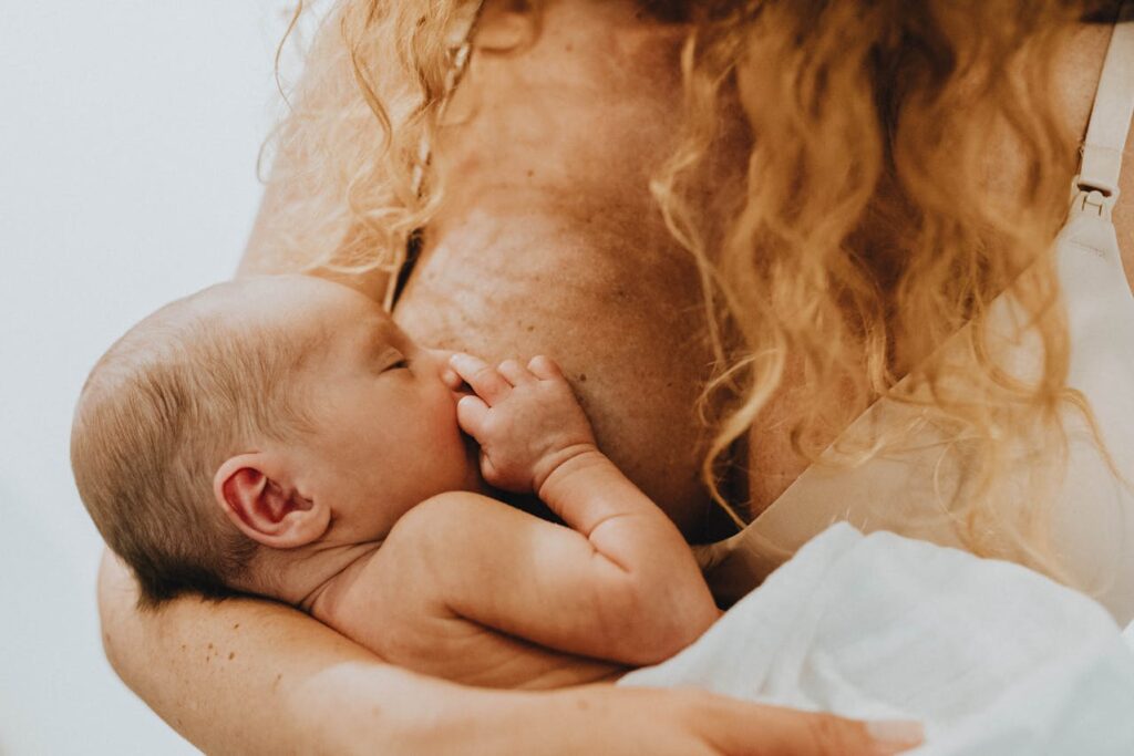 Woman Holding Child and Breastfeeding // Healthier Baby Today