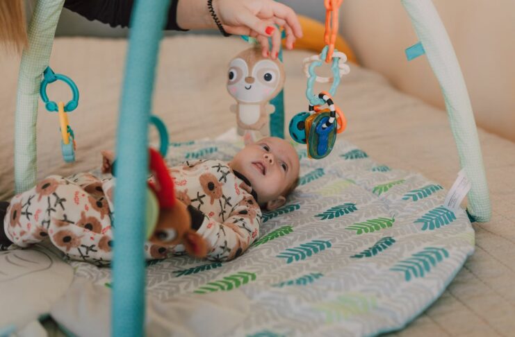 Baby Sensory Toys, A Cute Baby Lying Down while Looking at the Toys Hanging // Healthier Baby Today