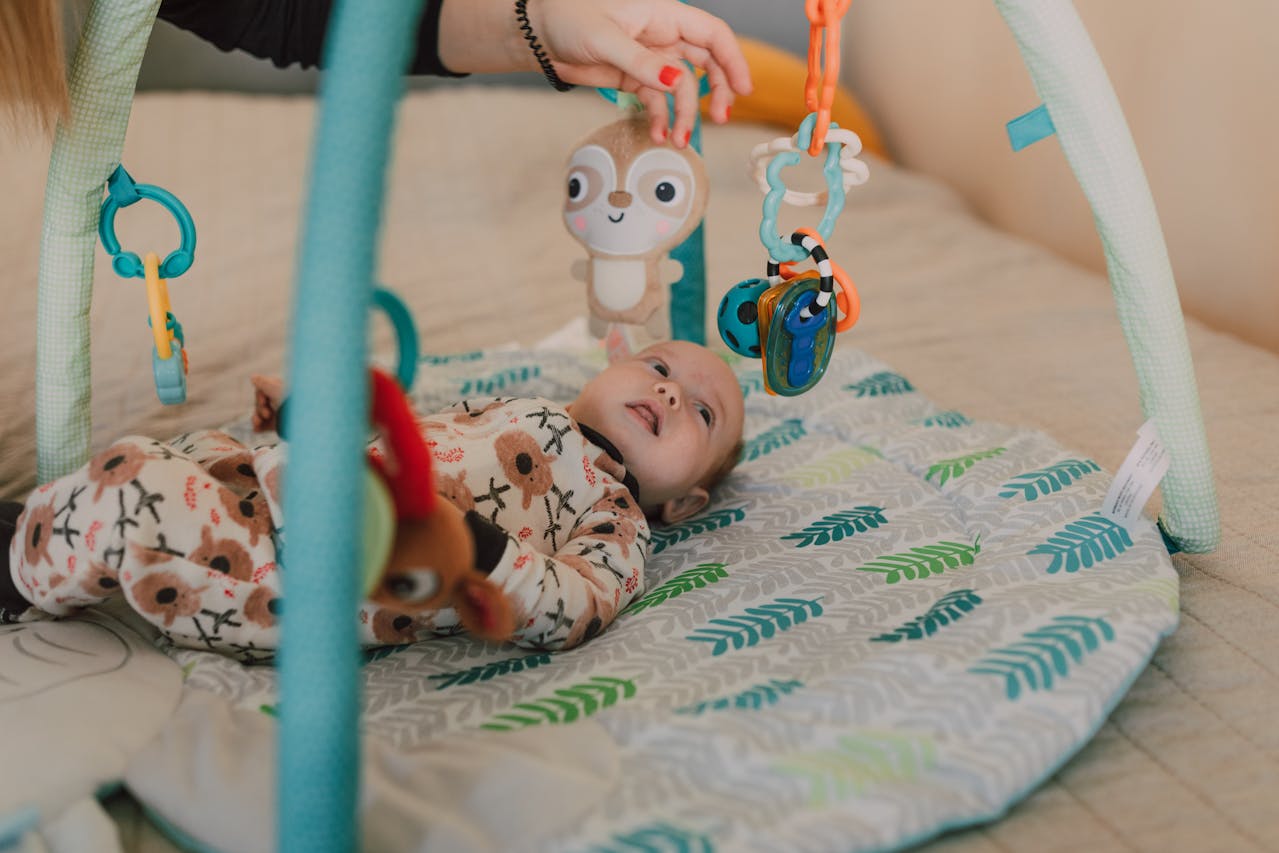 Baby Sensory Toys, A Cute Baby Lying Down while Looking at the Toys Hanging // Healthier Baby Today
