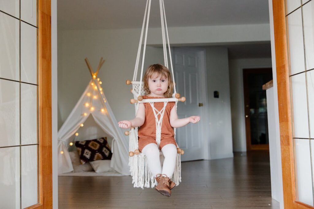 Adorable girl sitting on swing at home // Healthier Baby Today