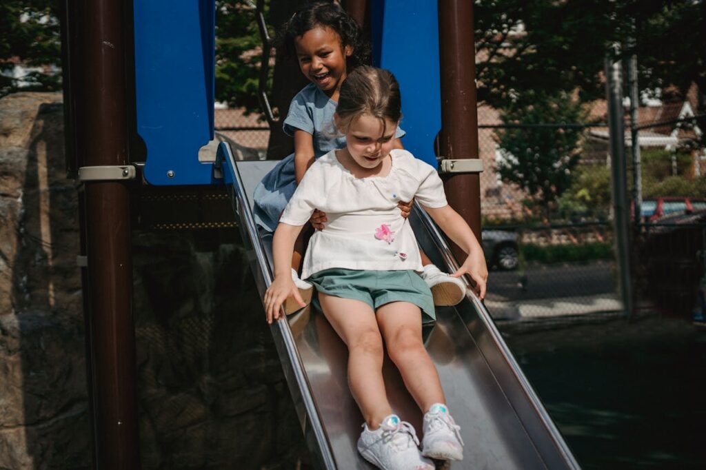 Girls Sliding in the Playground // Healthier Baby Today