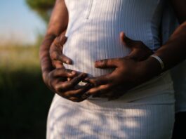 Hands Of A Couple Embracing The Baby Inside Her Growing Belly // Healthier Baby Today