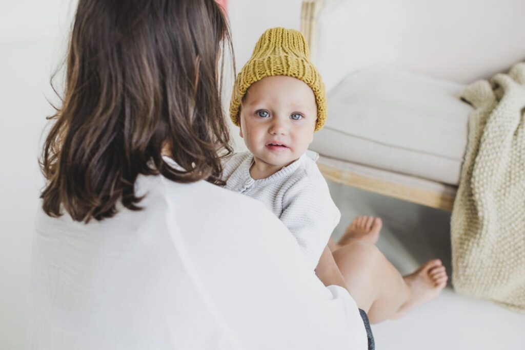 Mother Holding a Cute Baby in a Knitted Beanie // Healthier Baby Today