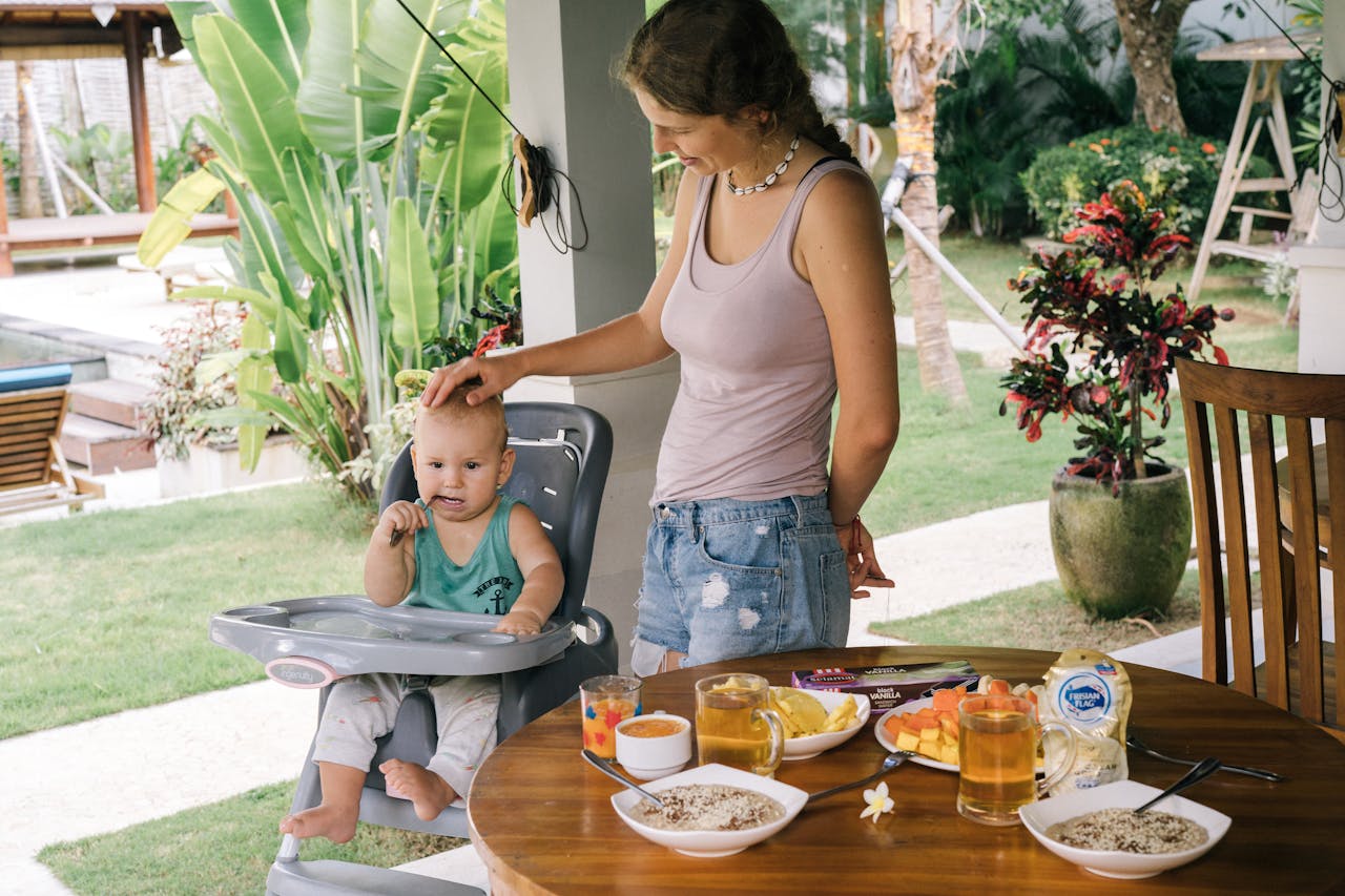 Baby Travel Essentials, Mother Looking at Her Cute Baby Sitting on a High Chair // Healthier Baby Today