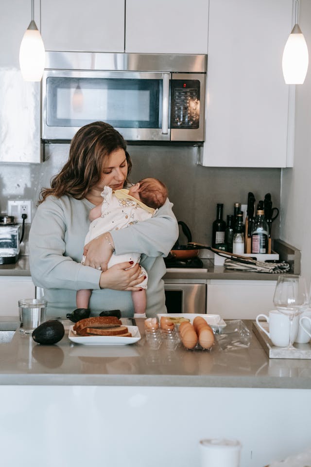 Woman with infant baby near kitchen counter // Healthier Baby Today