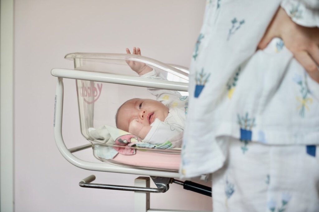 A Newborn Baby Lying in a Hospital Infant Bassinet // Healthier Baby Today