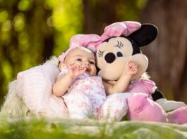 Newborn Photoshoot, Baby Girl Laying with a Minnie Mouse Plushie in a Park // Healthier Baby Today