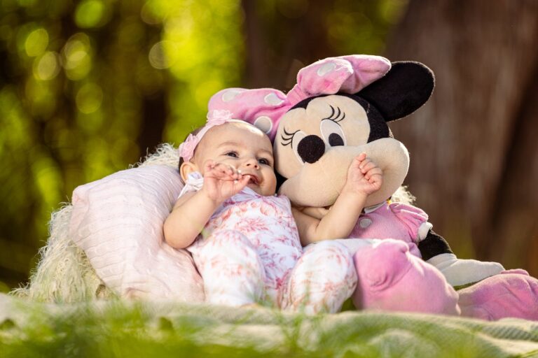 Newborn Photoshoot, Baby Girl Laying with a Minnie Mouse Plushie in a Park // Healthier Baby Today