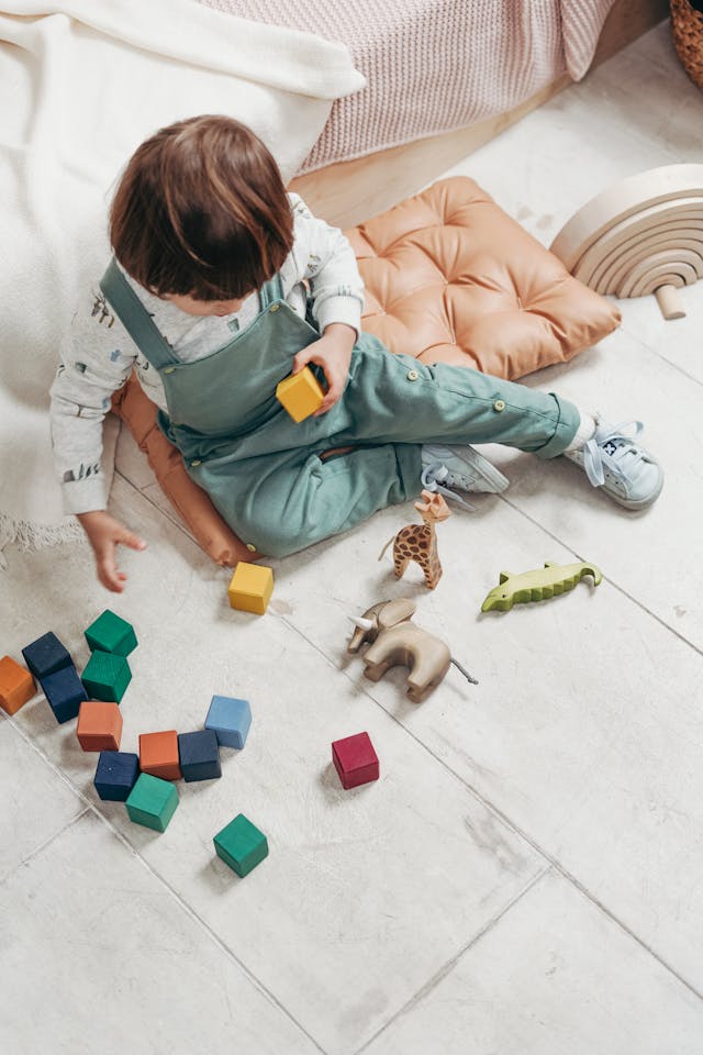 Child in White Long-sleeve Top and Dungaree Trousers Playing With Lego Blocks // Healthier Baby Today