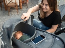 How To Get Newborn To Sleep In Bassinet, Woman Looking at Her Baby in a Stroller // Healthier Baby Today