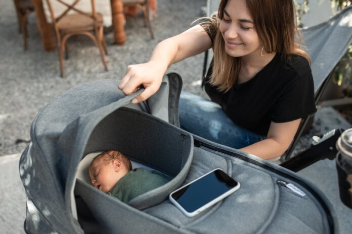 How To Get Newborn To Sleep In Bassinet, Woman Looking at Her Baby in a Stroller // Healthier Baby Today