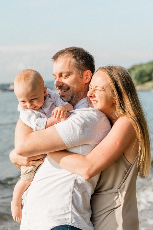 Family with a Little Baby Cuddles on the Beach // Healthier Baby Today