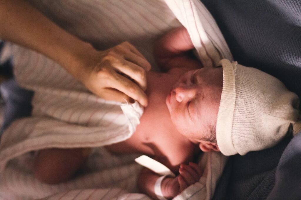 Newborn baby covered in a blanket // Healthier Baby Today