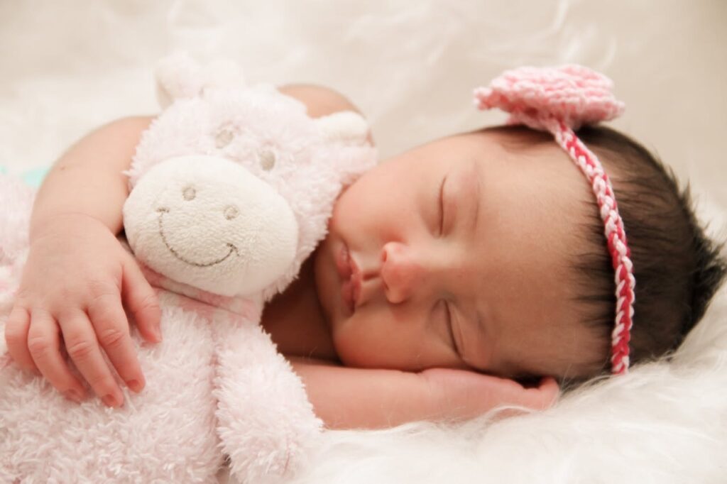 Baby sleeping with animal plush toy // Healthier Baby Today