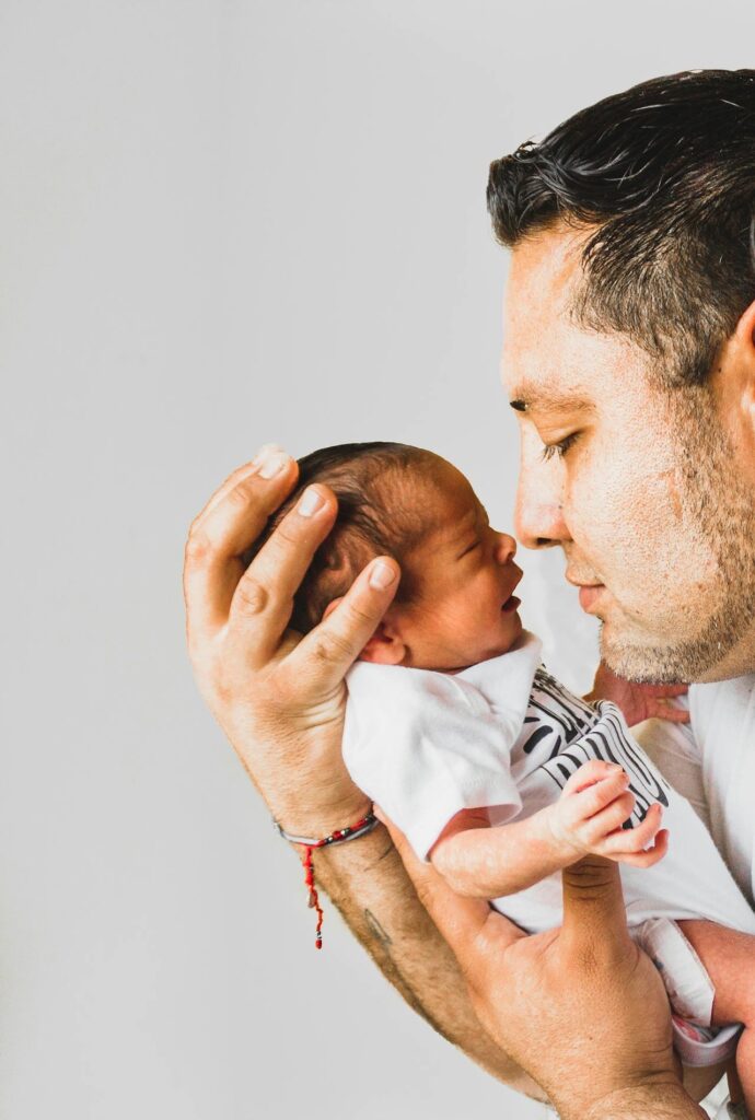 Father holding newborn baby // Healthier Baby Today