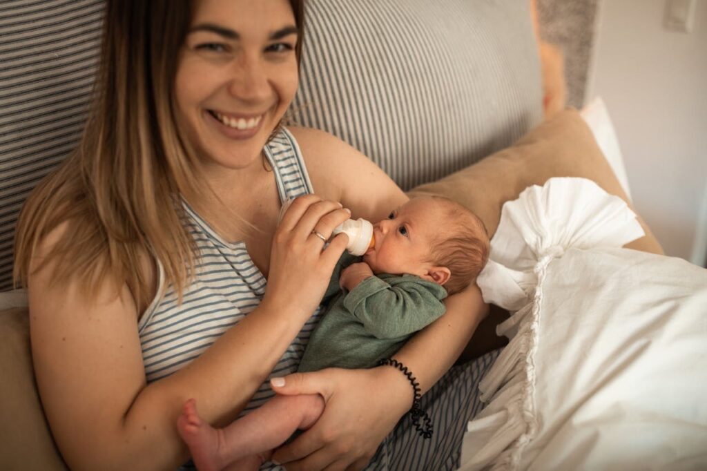 Woman holding her baby while feeding and smiling // Healthier Baby Today