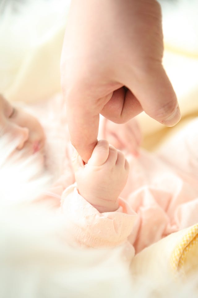 Baby holding an adults finger // Healthier Baby Today