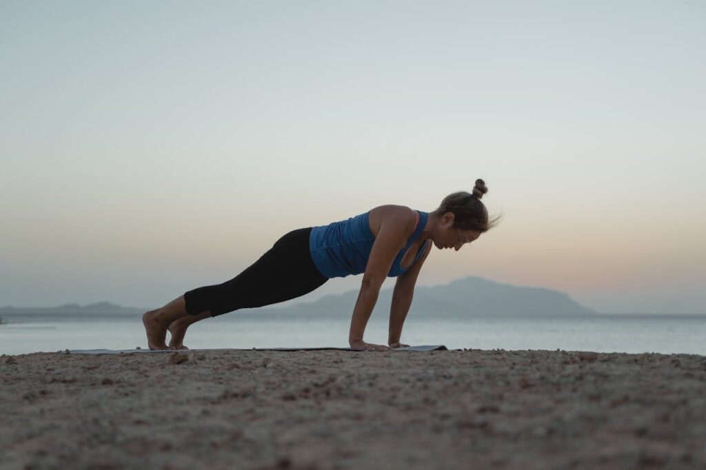 Woman doing yoga on the beach // Healthier Baby Today