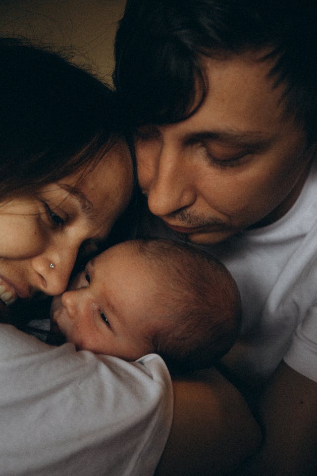 Mother and Father Embracing Little Baby // Healthier Baby Today