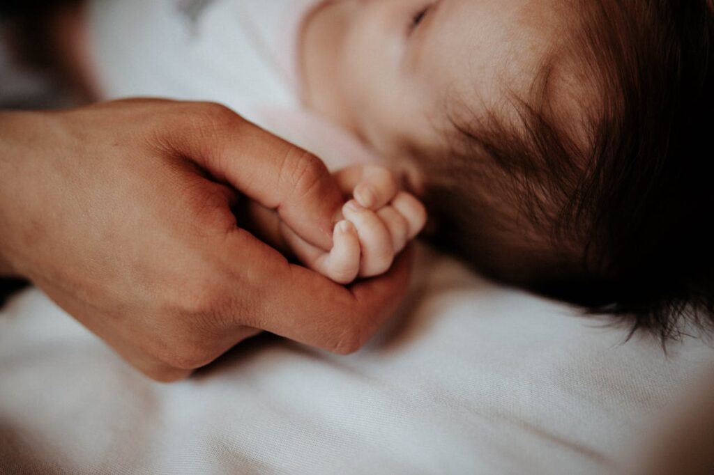 Close-up of the Father Holding His Newborn Baby Hand // Healthier Baby Today