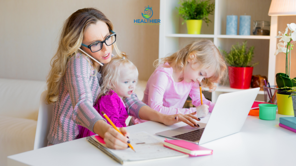 Mom working from home with two kids on her lap, she is on the phone and trying to write something down // Healthier Baby Today